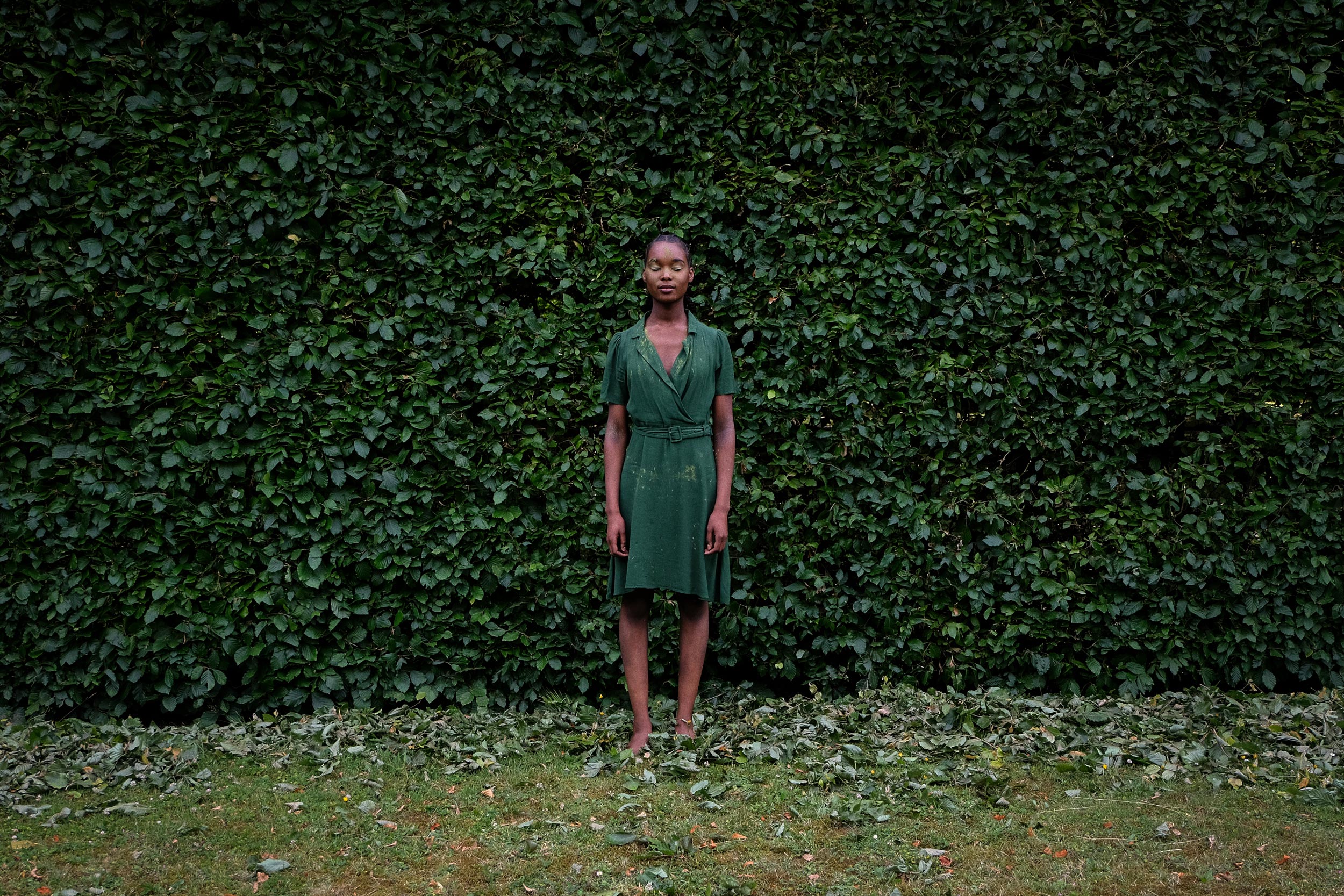 photo of woman standing in front of a bush